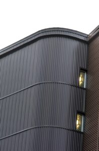 Close-up view of a modern building facade with metal siding and windows in Winnipeg, Canada.